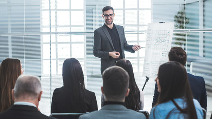speaker is pointing at a flip chart during your business presentation