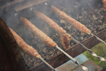Stuffed meat on skewers. Cooking lula kebab in the fresh air close-up.