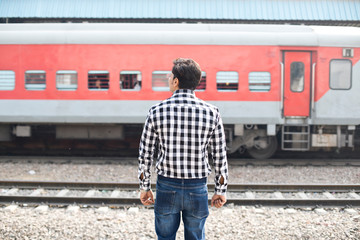 Rear view of man standing at railroad station