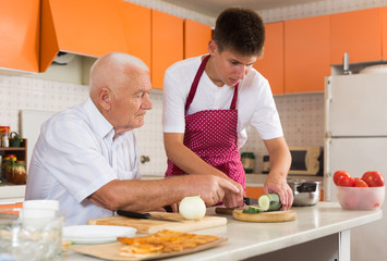 Fototapeta na wymiar Grandfather teaching grandson to cook