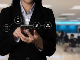Hand holding smart phone screen in bank.