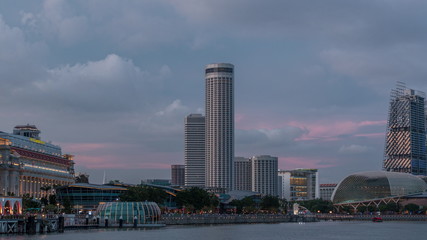 Obraz premium City skyline with skyscrapera and Esplanade Theatres on the Bay in Singapore at dusk, with beautiful reflection in water day to night timelapse