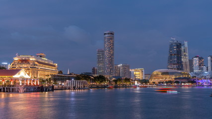 Fototapeta na wymiar City skyline with skyscrapera and Esplanade Theatres on the Bay in Singapore at dusk, with beautiful reflection in water day to night timelapse