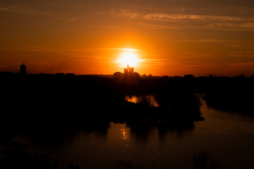 Fototapeta premium Sunset over Belgrade, Serbia from Kalemegdan Fortress. Panorama View of city skyline ,Danube and Sava rivers merging. Silhouettes of skyscrapers in the distance