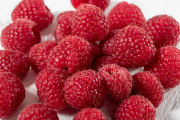 Ripe raspberry on white wooden background