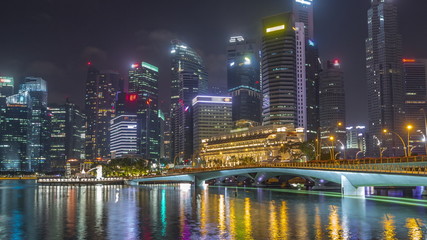 Fototapeta na wymiar Esplanade bridge and downtown core skyscrapers in the background Singapore night timelapse hyperlapse