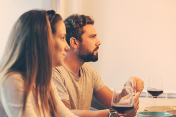 Relaxed couple enjoying dinner with friends. Young man and woman in casual meeting indoors. Dinner with friends concept