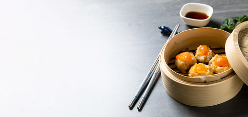 Egg yolk on a pork. Chinese Traditional cuisine concept. Dumplings Dim Sum in bamboo steamer with text copy space. Asian food background