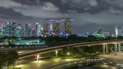 Fototapeta na wymiar Aerial view Singapore city skyline with colorful fountain at Marina barrage garden night timelapse hyperlapse.