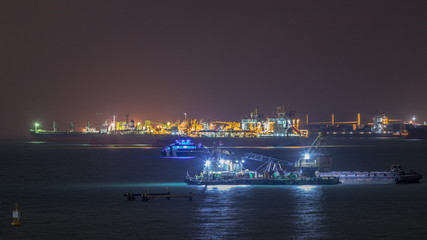 Singapore Marina Barrage with cargo ships waiting to enter one of the busiest ports in the world night timelapse, Singapore.