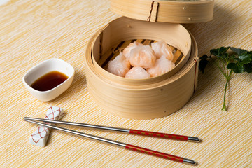 HAR GOW in bamboo steamer with sauces and chopsticks. Chinese Traditional cuisine concept. Dumplings Dim Sum in bamboo steamer with text copy space. Asian food background