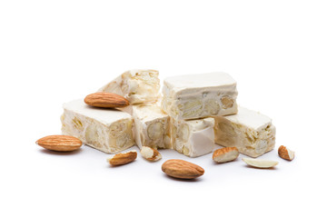 small nougat pieces with almonds, on white background. - obrazy, fototapety, plakaty