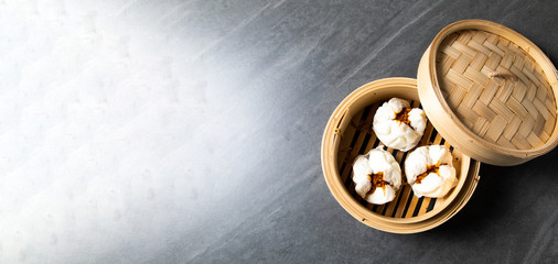 肉まん. steamed pork bun. Chinese Traditional cuisine concept. Dumplings Dim Sum in bamboo steamer with text copy space. Asian food background