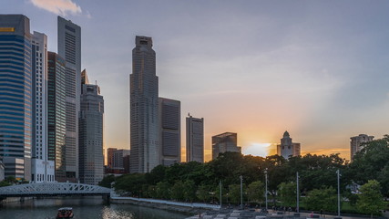 Fototapeta na wymiar Singapore skyscrapers skyline with white Anderson Bridge near esplanade park day to night timelapse.