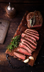 Sliced medium rare grilled beef steak with salt, rosemary and garlic - 334952660