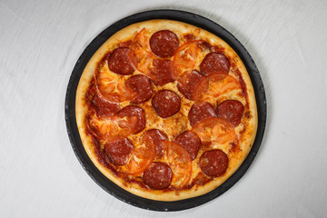 Italian pizza on gray plates on a white plate with spices and seasonings vegetables and meat.