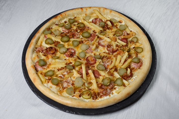 Italian pizza on gray plates on a white plate with spices and seasonings vegetables and meat.