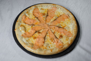 Italian pizza on gray plates on a white plate with spices and seasonings vegetables and meat.