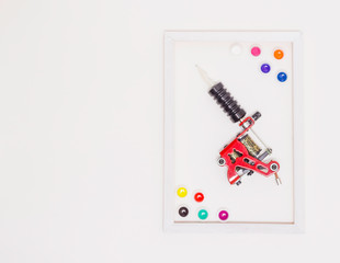 tattoo machine on a white background, white frame, free space for text, colored tattoo ink in...