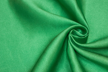 Smooth elegant green silk or satin luxury cloth texture can be used as abstract background. Crumpled fabric Twisted at the side.