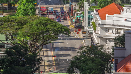 Naklejka premium Traffic with cars on a street and urban scene in the central district of Singapore timelapse
