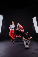 Fototapeta na wymiar A team of three people poses in a photo studio. bright costumes. on a dark background. creative team.