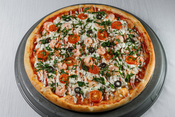 Italian pizza on gray plates on a white plate with spices and seasonings vegetables and meat.