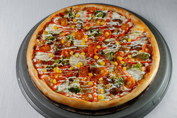 Italian pizza on gray plates on a white plate with spices and seasonings vegetables and meat.