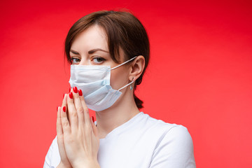 Brunette Caucasian woman in aseptic mask with hands together. Model in mask praying for the world. Brunette woman in protective mask keeping calm with her hands pressed.