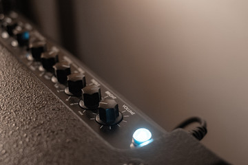 black amplifier knobs with a blue bright light