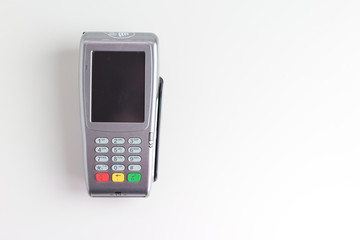 Terminal de cobro con tarjeta de crédito sobre fondo blanco.