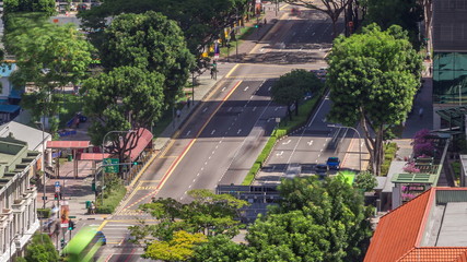 Fototapeta premium Traffic with cars on a street and urban scene in the central district of Singapore timelapse
