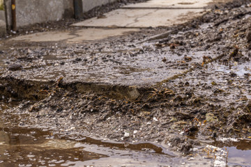 a muddy stream runs over concrete tiles