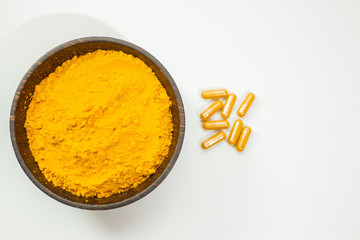 Turmeric capsule and roots curcumin on black background