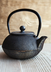 Obraz na płótnie Canvas Close up black metall tea pot on a wooden background