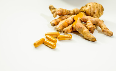 Turmeric powder and fresh turmeric on wooden background.