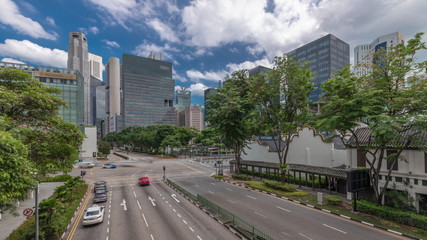Obraz premium Traffic with cars on a street and urban scene in the central district of Singapore timelapse