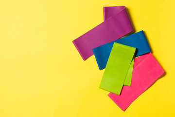 Fitness elastic bands for sports on a yellow background. Sports equipment. Top view with space for text. Banner