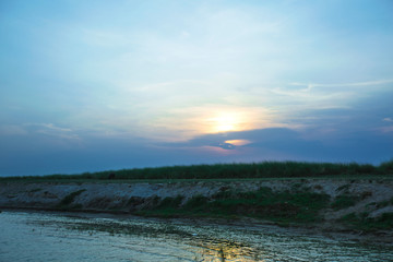 cloudy sunset with river water reflection. river side landscape with amazing sunset  | ganga yamuna river sunset image