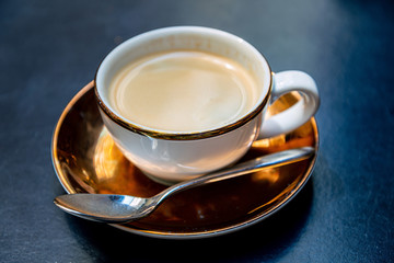 White cup of hot coffee on table