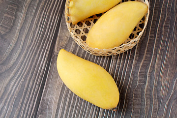 Yellow mango in basket on wood table. Top view. Copy space. Zero Waste