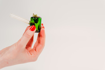 Cannabis. Female hand holds a smoking pipe with marijuana.