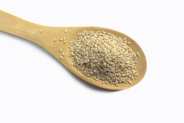 Sesame seeds on a wooden spoon isolated
