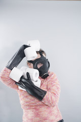 a woman in a gas mask and gloves takes all the toilet paper from the store during the coronovirus covid epidemic