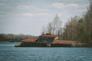 Flooded embankment and house in the exclusion zone. Chernobyl Pripyat. Ukraine.