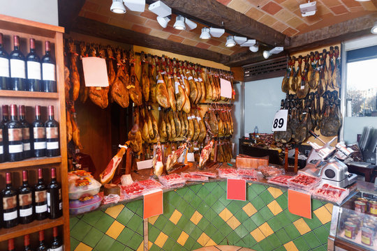 Assortment of traditional Spanish meat shop with dangling legs jamon