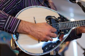 Close up of a musician playing Greek music on a Bouzouki