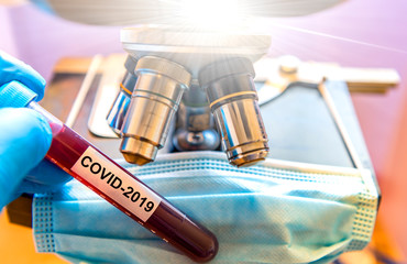 Protective gloves holding   COVID-19 or CoronaVirus test tube for blood sample analyses, routine...
