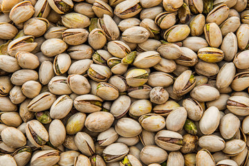 Toasted and salted pistachios in shell as a background