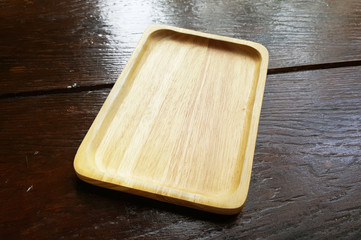 Close-up blank rectangular Asian style serving wooden tray on dark brown table at forest floating market gourmet restaurant, graphic design component, rough texture backgrounds